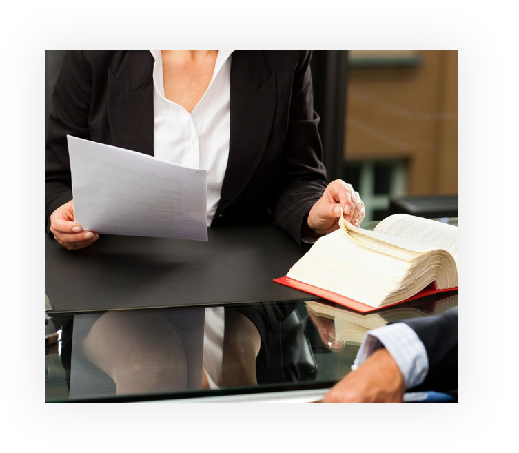 A woman holding papers and a book in front of another person.