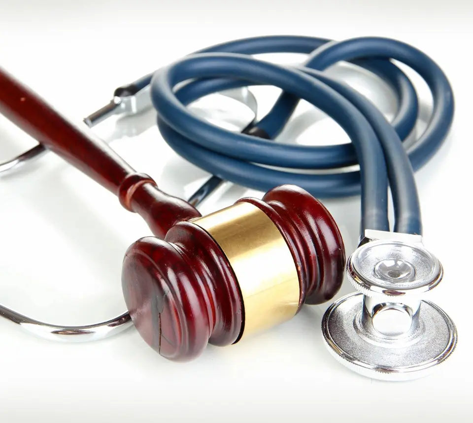 A judge 's gavel and stethoscope on top of the table.