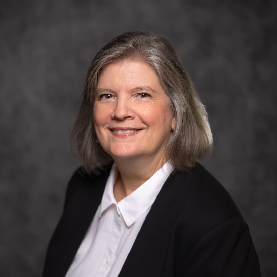 A woman in black jacket and white shirt.